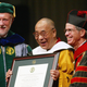 Adobe co-founder and University of San Francisco chairman Charles Geschke (left) presents an honorary degree to the Dalai Lama alongside USF president Steven Privett (right) in San Francisco, California in 2003.